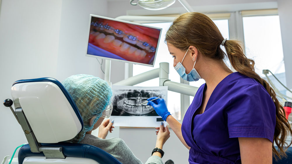 coulthard sullivan dentist discusses with patient their oral surgery showing them xrays and images